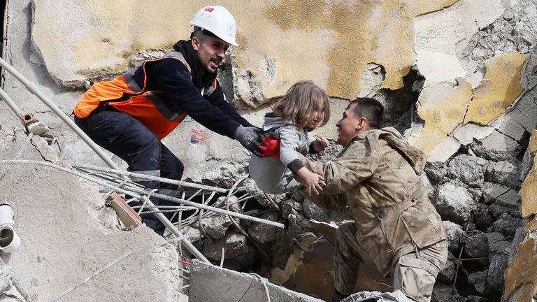 Muhammet Ruzgar, 5, is carried out by rescuers from the site of a damaged building, following an earthquake in Hatay, Turkey