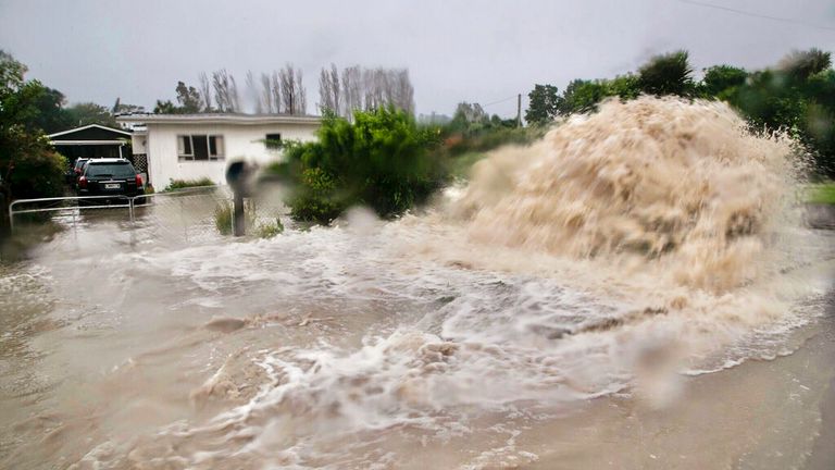 Water gushes from a storm on a street in Te Awanga, southeast of Auckland,. Pic: AP