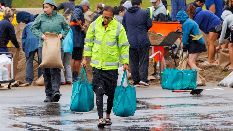 People fill up sandbags at a public collection point in preparation for the arrival of Cyclone Gabrielle in Auckland, New Zealand, February 12, 2023. AAP Image/David Rowland via REUTERS ATTENTION EDITORS - THIS IMAGE WAS PROVIDED BY A THIRD PARTY. NO RESALES. NO ARCHIVE. AUSTRALIA OUT. NEW ZEALAND OUT