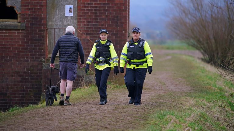 Police officers walk along a footpath in St Michael&#39;s on Wyre