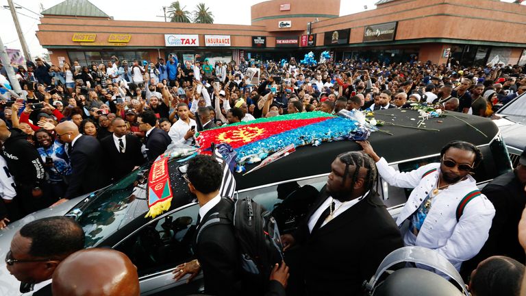 People watch the procession of a hearse of the late rapper Nipsey Hussle as it passes in front of The Marathon Clothing store, where Hussle was shot and killed last week, in Los Angeles, California, U.S., April 11, 2019. REUTERS/Patrick T. Fallon
