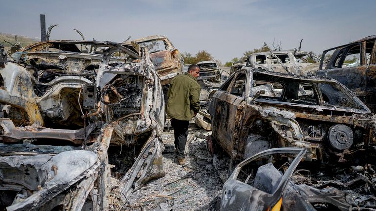 A Palestinian man walks between scorched cars in a scrapyard in the town of Hawara Pic: AP 