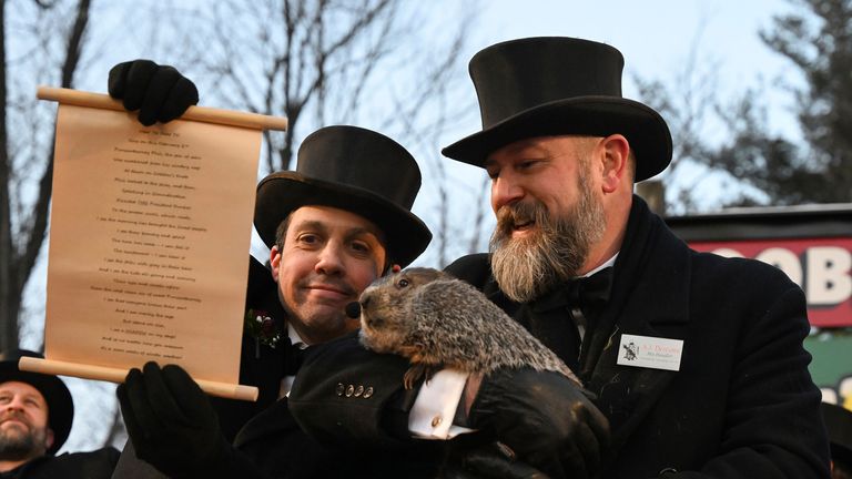 Groundhog Club handler A.J. Dereume holds Punxsutawney Phil, the weather prognosticating groundhog, while Vice President Dan McGinley reads the scroll during the 137th celebration of Groundhog Day on Gobbler&#39;s Knob in Punxsutawney, Pa., Thursday, Feb. 2, 2023. Phil&#39;s handlers said that the groundhog has forecast six more weeks of winter. (AP Photo/Barry Reeger)