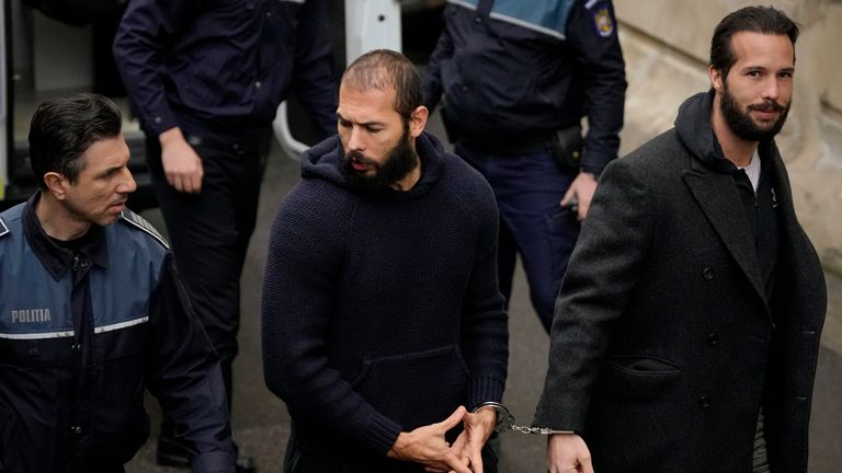 Police officers escort Andrew Tate handcuffed to his brother Tristan Tate, to the Court of Appeal in Bucharest, Romania
