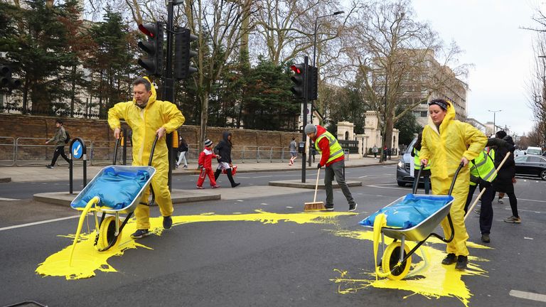 مجموعة احتجاجية بقيادة الحمير  صب الطلاء الأصفر على طريق ، قبل الذكرى السنوية الأولى لغزو روسيا لأوكرانيا ، خارج السفارة الروسية في لندن ، بريطانيا 