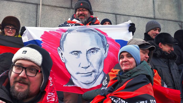 People at the concert pose with a flag depicting Vladimir Putin Pic: AP 