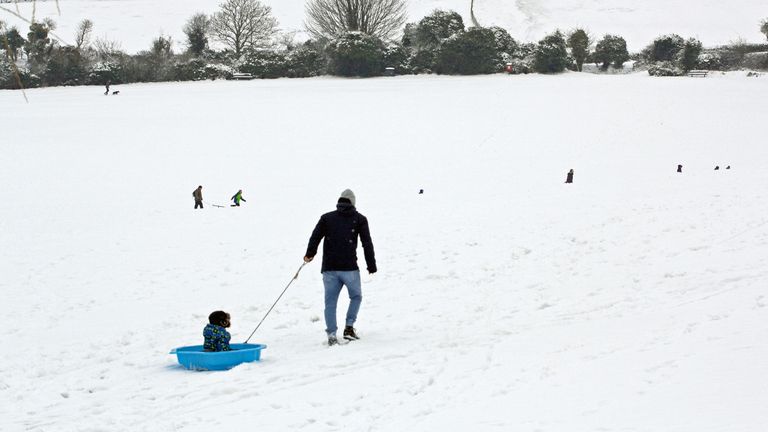 A man pulls a child along in a sledge in Salisbury, Wiltshire, as the wintry snap dubbed the &#39;Beast From the East&#39; in March 2018

