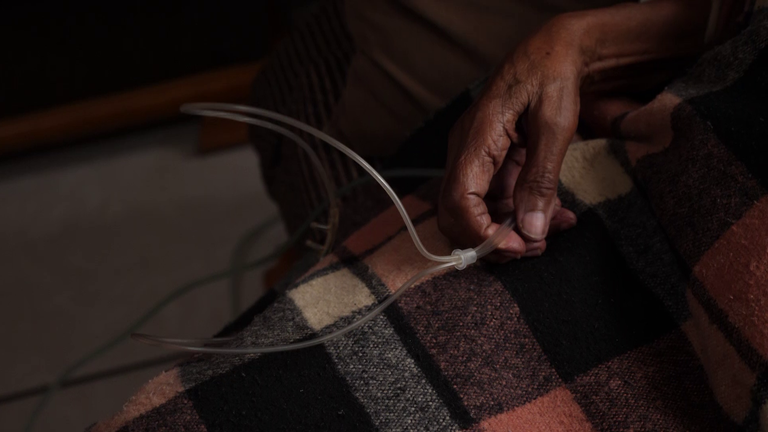 Jeanette holds the tube that helps her breathe