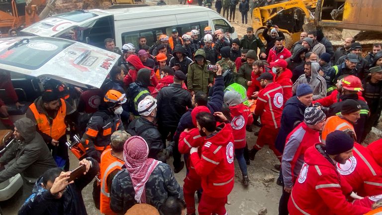 Rescuers work near the site of a collapsed building, following an earthquake, in Hama, Syria