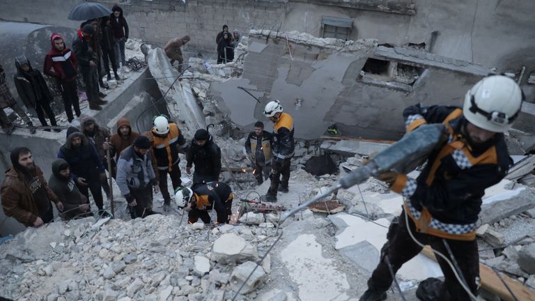 Rescuers search for survivors under the rubble in Idlib. Pic: White Helmets/Reuters 