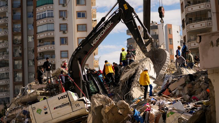 Acil durum ekipleri Adana, Türkiye'de yıkılan bir binada insanları arıyor Pic:AP