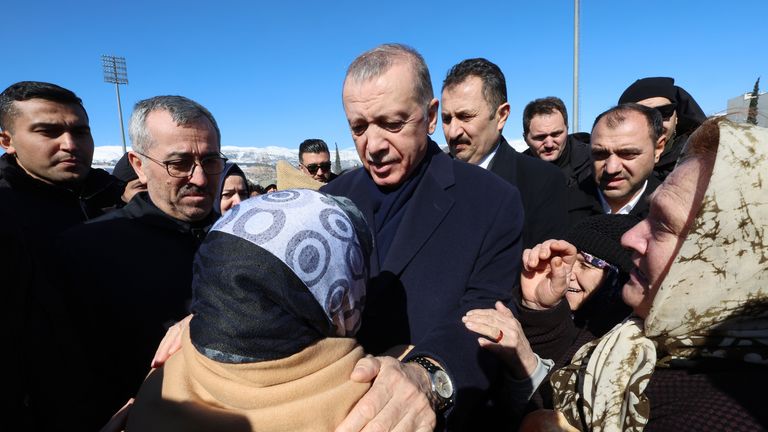Cumhurbaşkanı Recep Tayyip Erdoğan depremzede ile konuşuyor.  Resim: AP