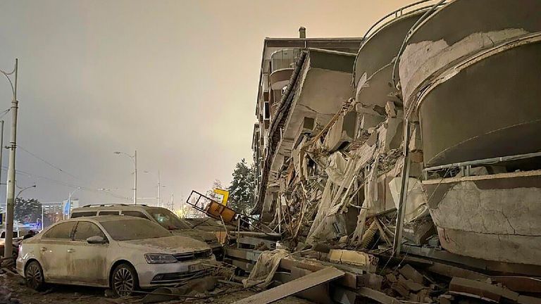Damaged vehicles sit parked in front of a collapsed building following an earthquake in Diyarbakir in southeastern Turkey. Pic: AP