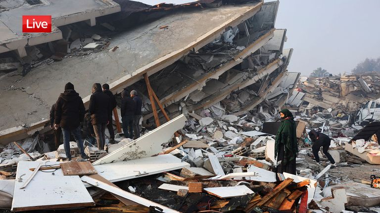 People look at rubble and damage following an earthquake in Hatay, Turkey