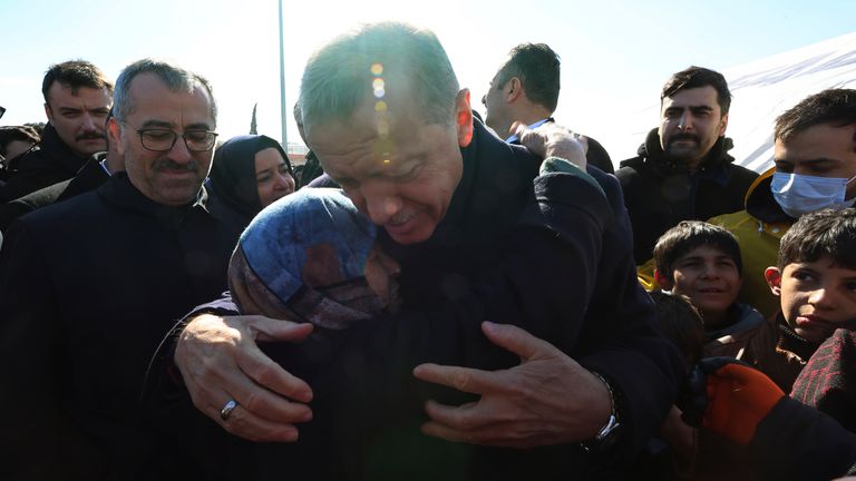 Turkey&#39;s President Recep Tayyip Erdogan hugs a survivor as he visits the city centre destroyed by the earthquake in Kahramanmaras, southern Turkey