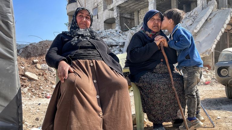 Elderly ladies sit near rubble in Jindiris 