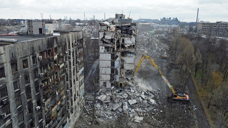 حفارة تهدم مبنى سكني متعدد الطوابق ، تم تدميره أثناء الصراع الروسي الأوكراني في ماريوبول ، أوكرانيا التي تسيطر عليها روسيا 