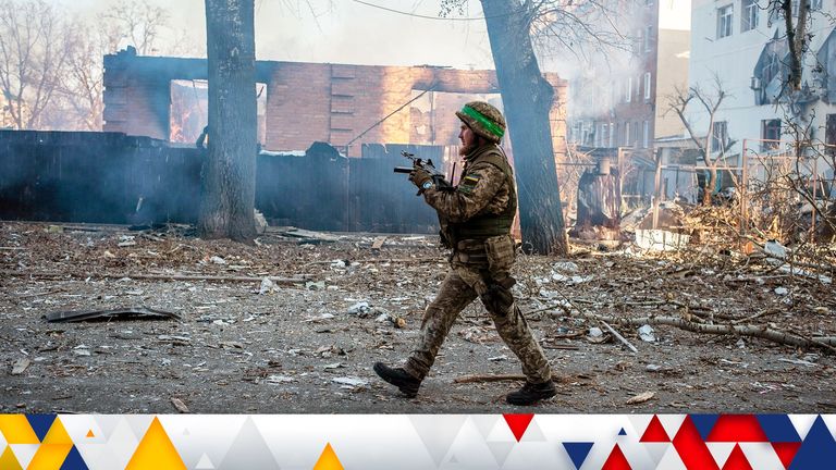 A Ukrainian service member walks next to a burning building in the frontline town of Bakhmut, amid Russia’s attack on Ukraine, in Donetsk region, Ukraine, in this handout picture released February 13, 2023. Iryna Rybakova/Press Service of the 93rd Independent Kholodnyi Yar Mechanized Brigade of the Ukrainian Armed Forces/Handout via REUTERS ATTENTION EDITORS - THIS IMAGE HAS BEEN SUPPLIED BY A THIRD PARTY.
