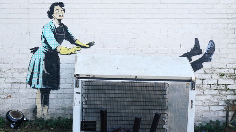 A new artwork by street artist Banksy, titled &#39;Valentine&#39;s Day Mascara&#39; on the side of a building in Margate, Kent. The artwork depicts a 1950&#39;s housewife, wearing a classic blue pinny and yellow washing up gloves, with a swollen eye and a missing tooth seemingly shoving her male partner into a chest freezer. 