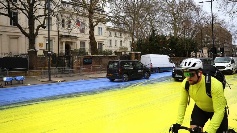 Vehicles drive on paint in the colours of the Ukrainian flag, after Protest group &#39;Led by Donkeys&#39; spread paint on the road, ahead of the first anniversary of Russia&#39;s invasion of Ukraine, outside the Russian Embassy in London, Britain February 23, 2023. REUTERS/Hannah McKay
