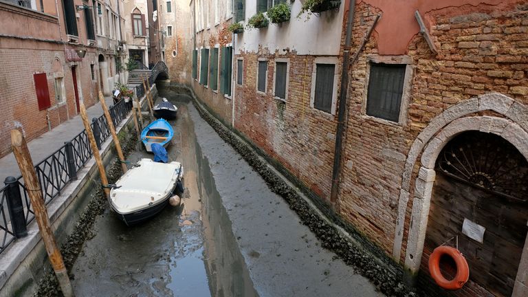 Boats are pictured in a canal during a severe low tide in the lagoon city of Venice, Italy, February 17, 2023. REUTERS/Manuel Silvestri REFILE - CORRECTING YEAR
