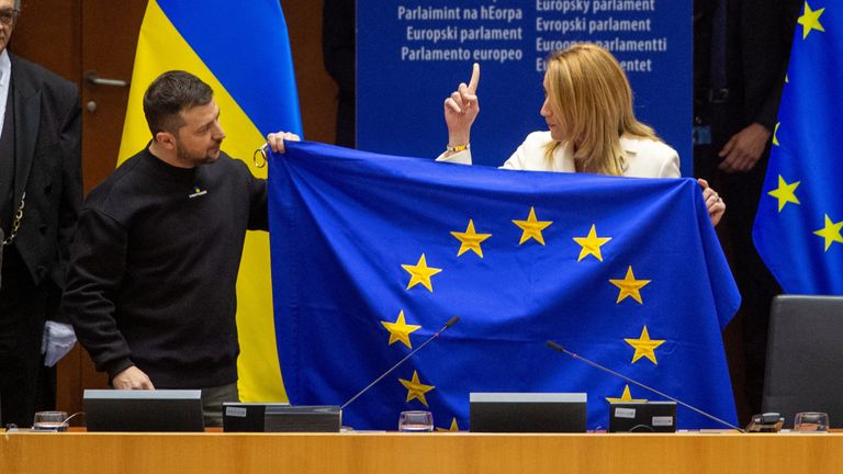 Roberta Metsola holds the EU flag with Ukrainian President Volodymyr Zelenskyy