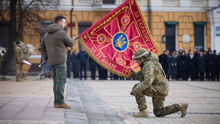 Ukraine's President Volodymyr Zelenskyy handovers a flag to a serviceman during a ceremony dedicated to the first anniversary of the Russian invasion of Ukraine, amid Russia's attack on Ukraine, in Kyiv, Ukraine February 24, 2023. Ukrainian Presidential Press Service/Handout via REUTERS ATTENTION EDITORS - THIS IMAGE HAS BEEN SUPPLIED BY A THIRD PARTY. THIS PICTURE WAS PROCESSED BY REUTERS TO ENHANCE QUALITY. AN UNPROCESSED VERSION HAS BEEN PROVIDED SEPARATELY.
