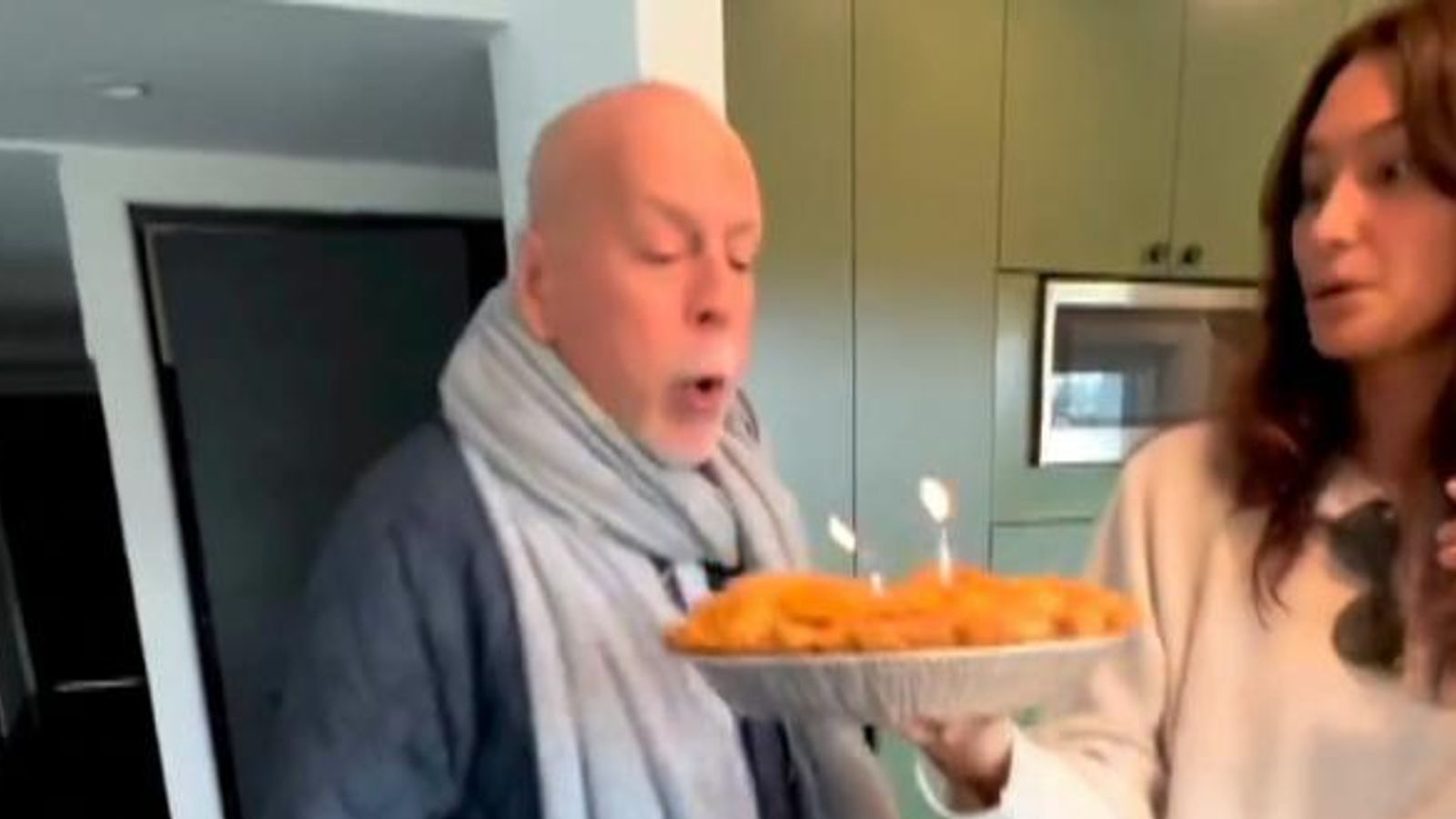 Bruce Willis sings and blows out candles as he celebrates 68th birthday