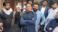 Imran Khan stands with supporters after security forces had made attempts to arrest him