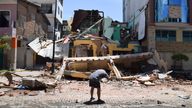 A man takes a photo of a building that collapsed after an earthquake shook Machala, Ecuado