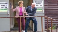 First Minister Nicola Sturgeon's husband Peter Murrell, Chief Executive of the SNP, comes up behind her as she poses for the media outside the Broomhouse Community Hall polling station, Glasgow, as voting begins in the local government elections. Picture date: Thursday May 5, 2022.