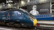 An Avanti West Coast train pulls up next to a new mural at Euston Station 