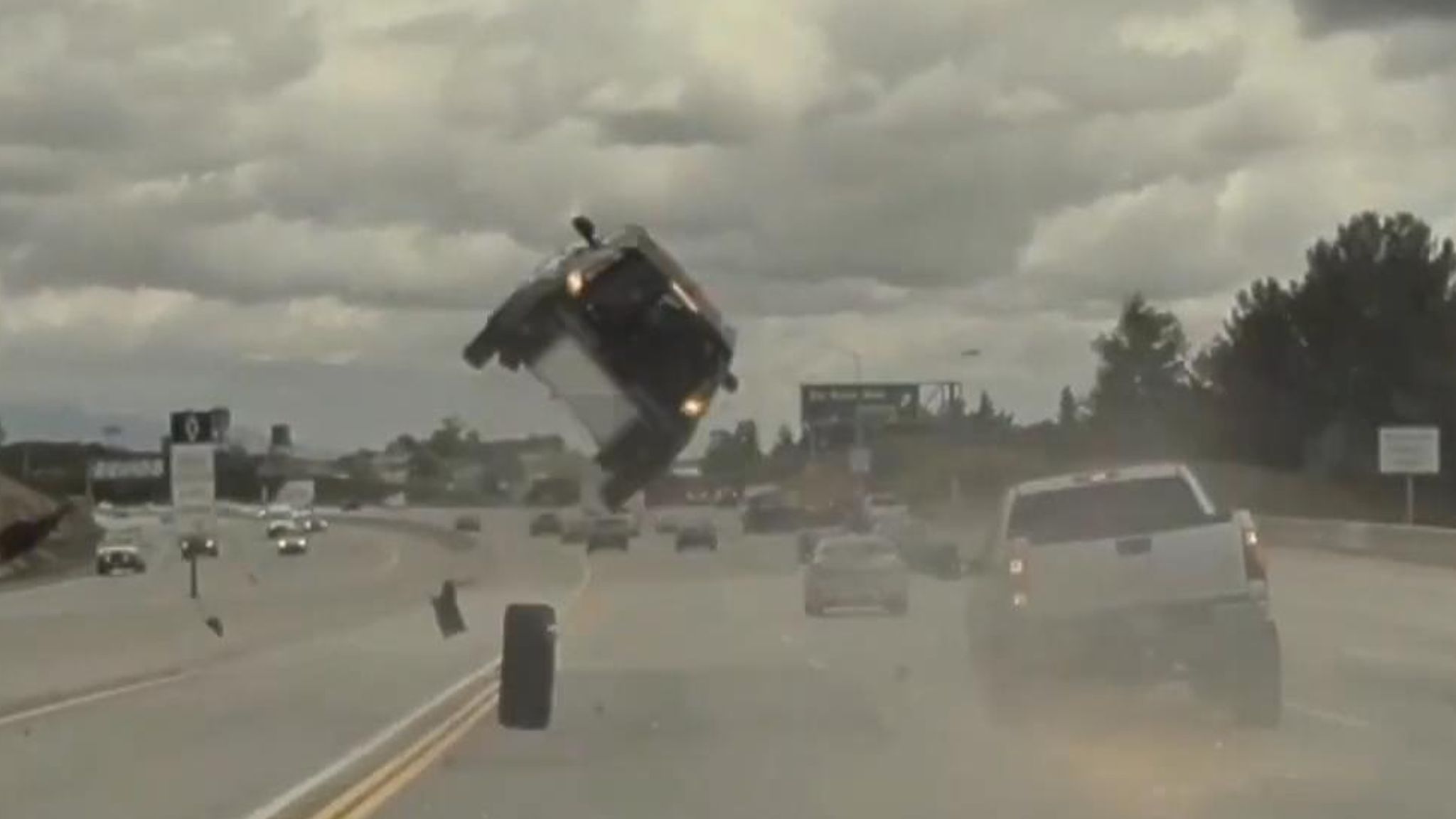 A car was sent flying several feet into the air after being hit by a loose  tyre from a pickup truck nearby.