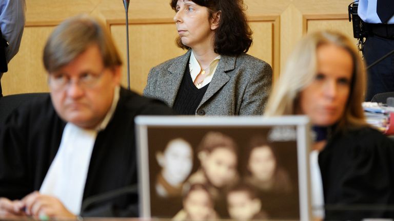 Genevieve Lhermitte (arkada, ortada), Aralık 2008'de Nivelles'teki Adalet Sarayı'nda duruşması sırasında beş çocuğunun fotoğrafının arkasında oturuyor.