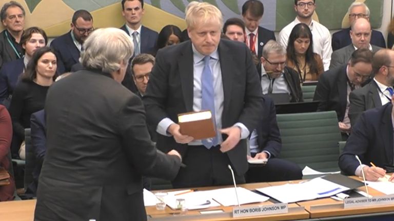 Le greffier du Comité (à gauche) fait prêter serment à l'ancien Premier ministre Boris Johnson avant son témoignage devant le Comité des privilèges de la Chambre des communes, à Londres.  Date de la photo : mercredi 22 mars 2023.