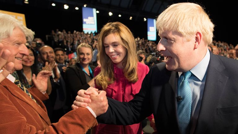 Prime Minister Boris Johnson leaves the stage with his partner Carrie Symonds as he is congratulated by his father Stanley Johnson after delivering his speech during the Conservative Party Conference at the Manchester Convention Centre.