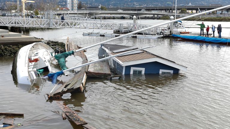 A boat and houseboat float submerged at Jack London Aquatic Center in Oakland, California