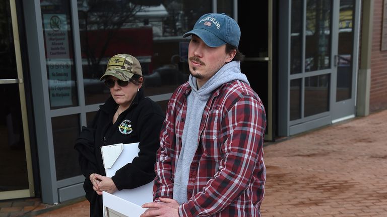 Shane Caviola with photos of his family's two dogs, Cimo, right, and Lieben.  Photo: AP