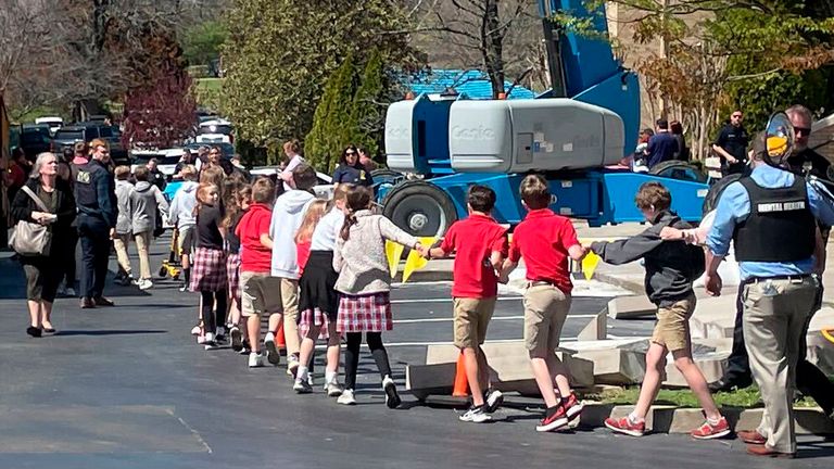 Covenant School children hold hands as they are taken to another area to be reunited with their parents