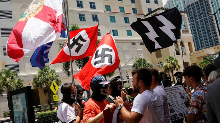 People waving Nazi swastika flags argue with conservatives during a protest outside the Tampa Convention Center, where Turning Point USA&#39;s (TPUSA) Student Action Summit (SAS) is being held, in Tampa, Florida, U.S. July 23, 2022. REUTERS/Marco Bello
