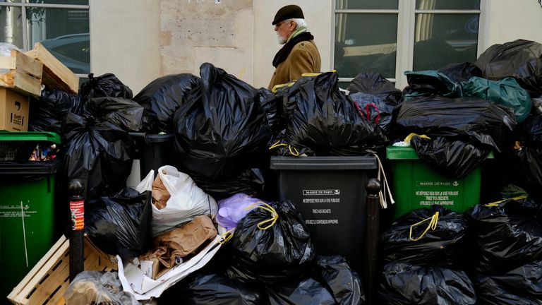 A man walks past uncollected garbage in Paris: AP