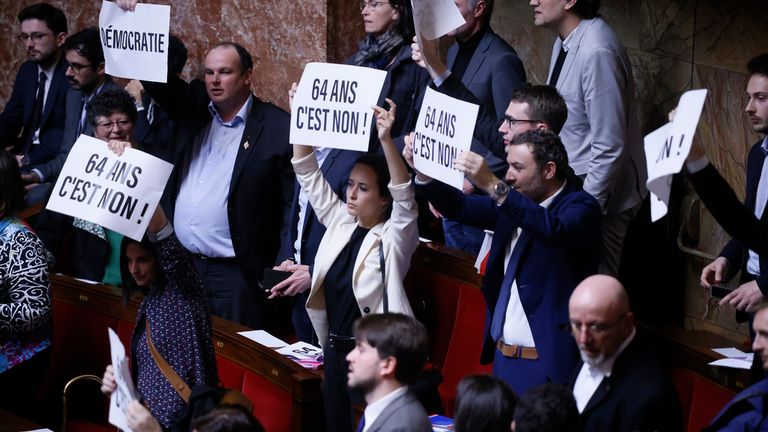Far-left lawmakers react as they hold papers reading. Pic AP
