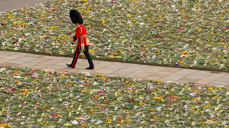 A member of the Coldstream Guards is seen walking past a bed of flowers during the State Funeral of Queen Elizabeth II