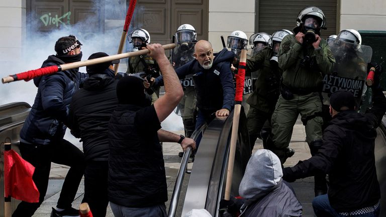 Yunanistan'ın Atina kentindeki Larissa kenti yakınlarında iki trenin çarpışmasının ardından bir gösteri sırasında Atina Metrosu çalışanı bir istasyonun girişine müdahale etmeye çalışırken protestocular çevik kuvvet polisiyle çatıştı, 5 Mart 2023. REUTERS/ Alkis Konstantinidis
