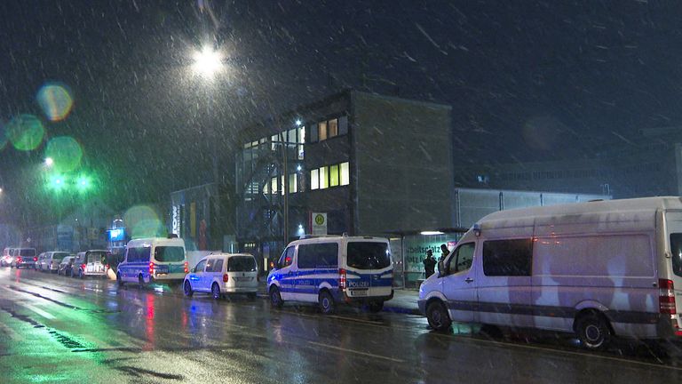Forensic vehicles stand in front of a Jehovah's Witnesses building in Hamburg after the shooting.