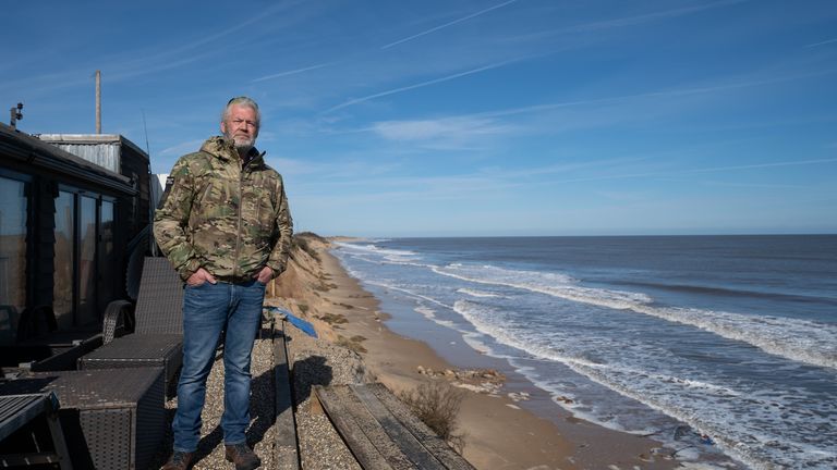 Hemsby resident Lance Martin looks out from his home on the cliff edge at Hemsby in Norfolk, where a number of residents have left their homes which are at risk of collapse as high tides cut into sandy cliffs. Picture date: Saturday March 11, 2023.