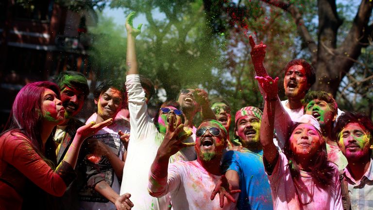 Bangladeshi youth throw coloured powder during the celebrations marking Holi