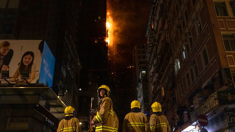 İtfaiyeciler, 3 Mart 2023 Cuma günü Hong Kong'daki bir inşaat sahasında çıkan yangına müdahale ediyor. Hong Kong itfaiyecileri, şehrin popüler alışveriş bölgesindeki bir inşaat sahasında çıkan yangınla mücadele ediyor.  (AP Fotoğrafı/Louise Delmotte)