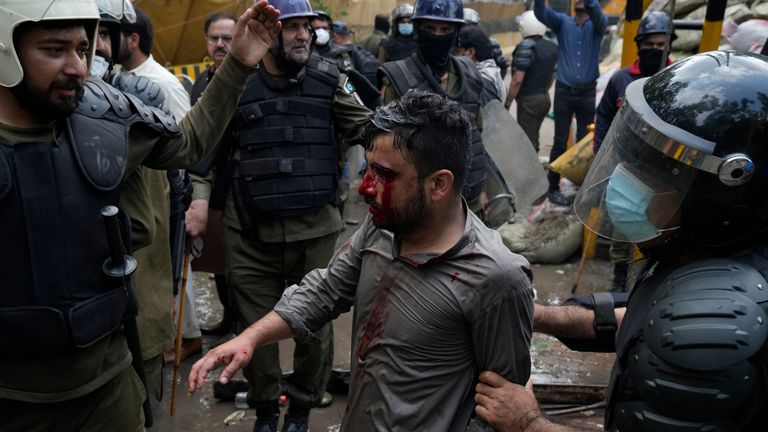 Police detain a supporter of former Prime Minister Imran Khan during a search operation at the Khan's residence in Lahore, Pakistan March 18, 2023. Pakistani police stormed the residence of the former Prime Minister Khan in the eastern city of Lahore on Saturday and arrested 61 people amid tear gas and clashes between Khan supporters and police, officials said.  (AP Photo/KM Chaudary)