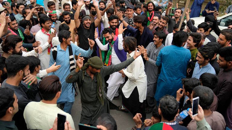 Supporters of Imran Khan dance outside his house in Lahore on Sunday